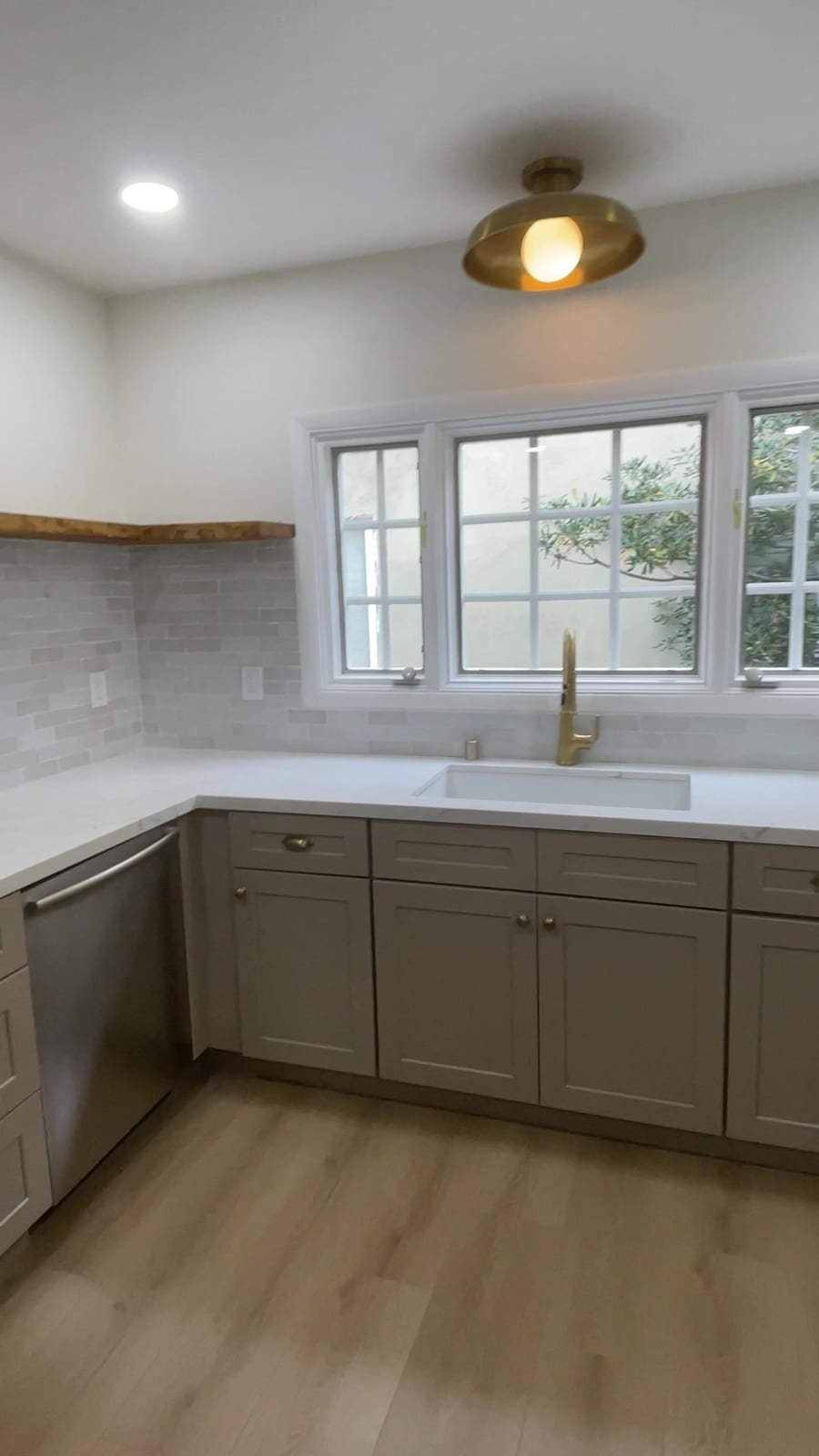 Finished kitchen with a brass light over the sink window